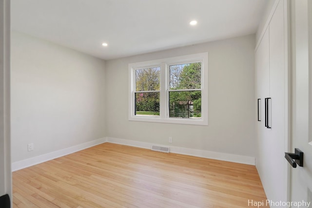 unfurnished room featuring wood finished floors, recessed lighting, and baseboards