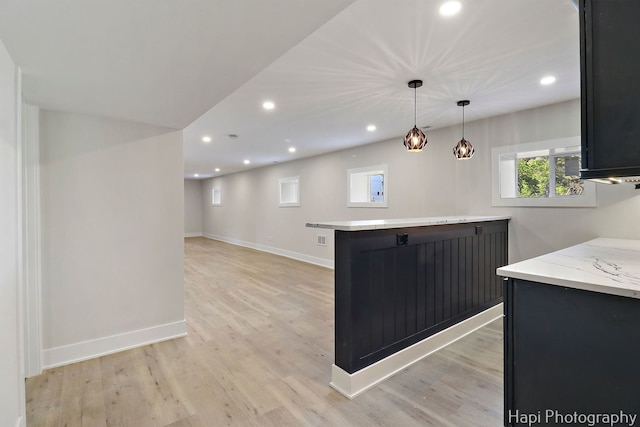 kitchen featuring recessed lighting, light wood-type flooring, baseboards, dark cabinetry, and pendant lighting
