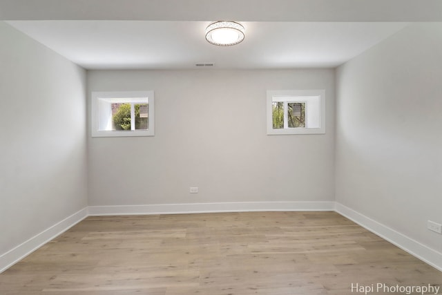 empty room with light wood finished floors and baseboards