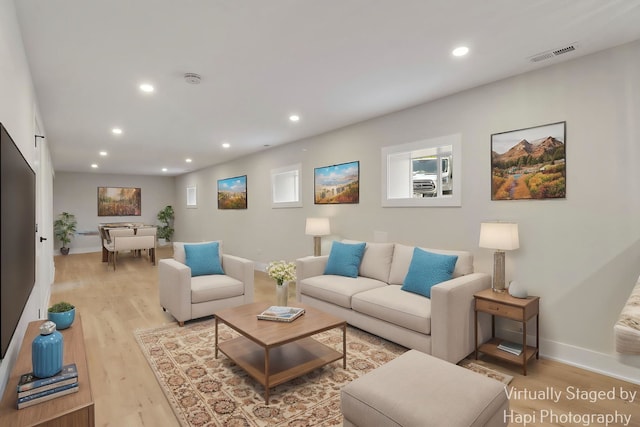 living room with recessed lighting, light wood-style flooring, and baseboards
