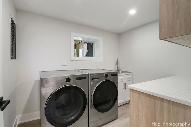 clothes washing area with cabinet space, separate washer and dryer, light wood finished floors, baseboards, and recessed lighting