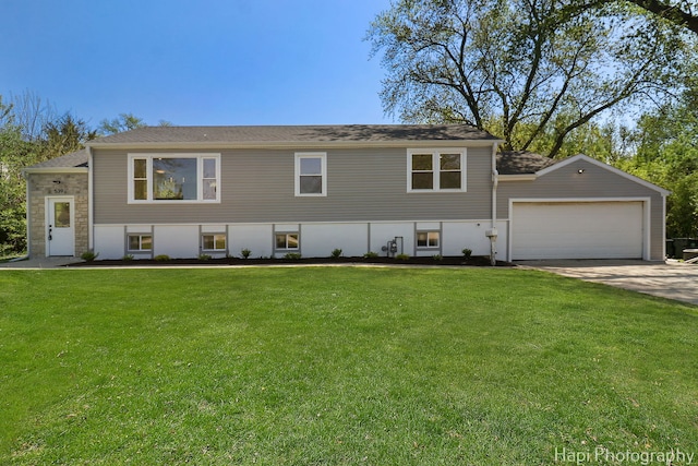 view of front of home featuring a front yard, an attached garage, and concrete driveway