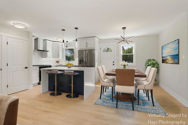 dining room featuring light wood-style flooring and baseboards