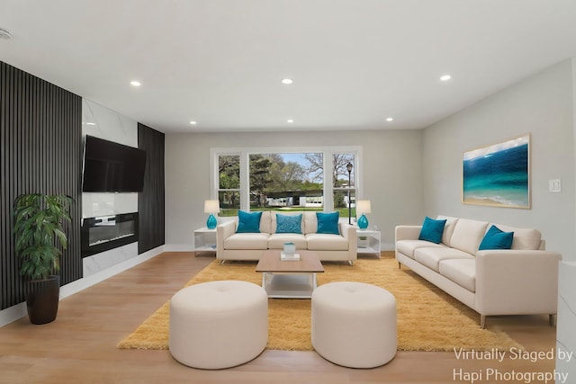 living room with light wood-style floors, recessed lighting, and baseboards