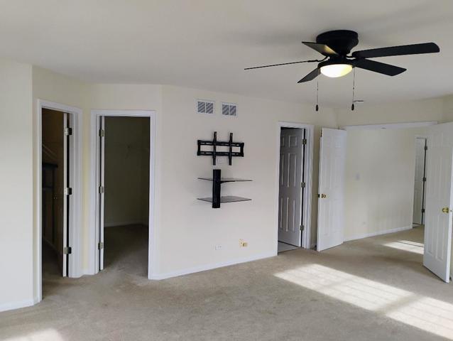 spare room featuring ceiling fan and light carpet