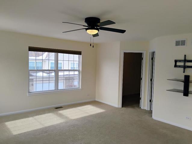 carpeted empty room featuring ceiling fan