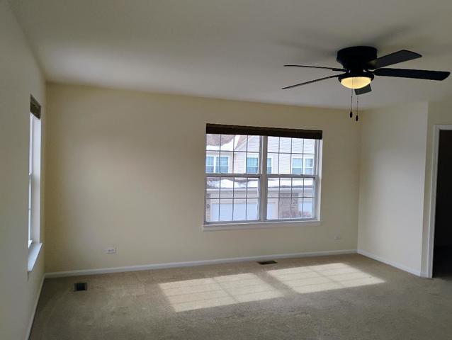 carpeted empty room featuring ceiling fan