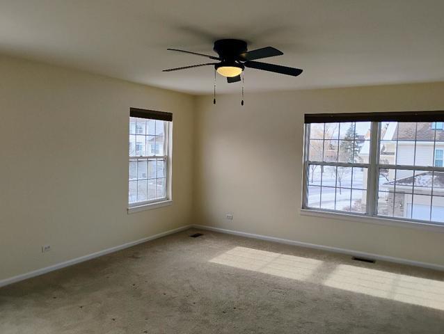 empty room with ceiling fan and light colored carpet