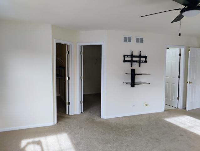 carpeted spare room with ceiling fan