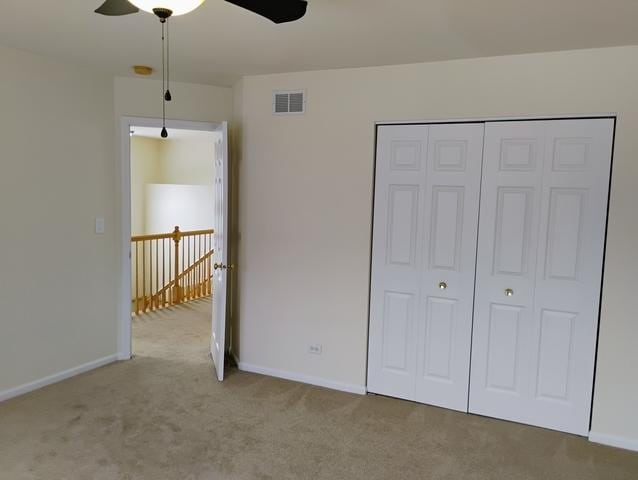 unfurnished bedroom featuring carpet floors, a closet, and ceiling fan