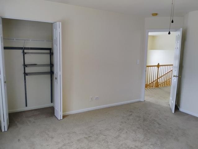 unfurnished bedroom with light carpet and a closet