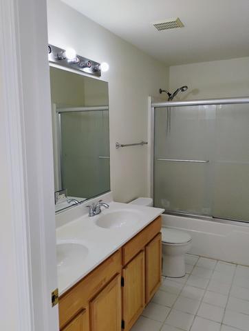 full bathroom featuring toilet, vanity, and shower / bath combination with glass door