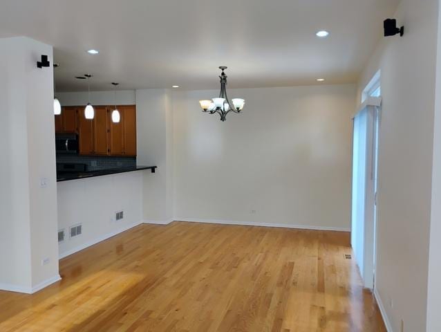 interior space with an inviting chandelier and light hardwood / wood-style flooring