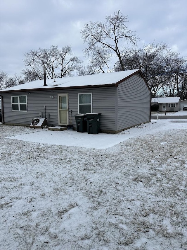 view of snow covered rear of property