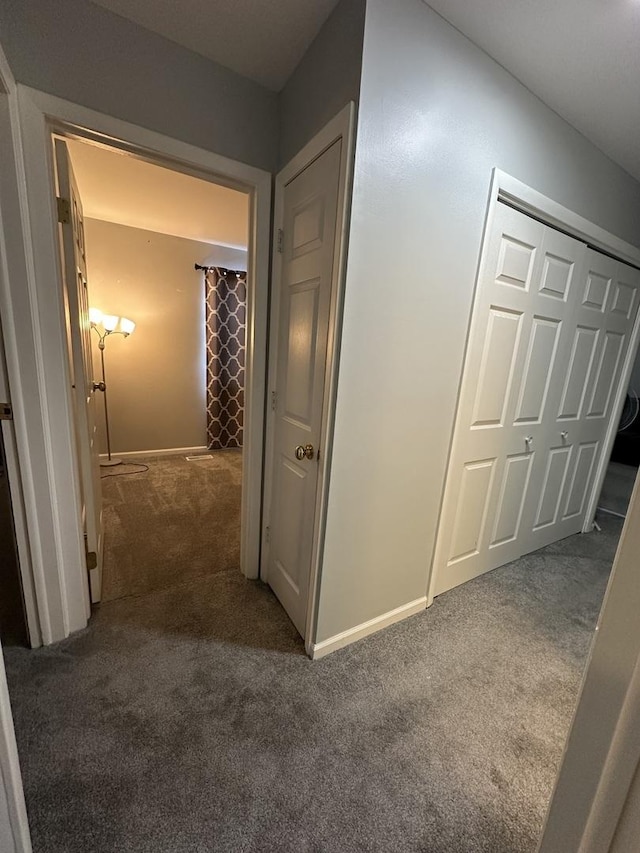 hallway featuring dark carpet