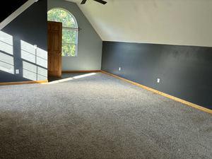 bonus room with vaulted ceiling and carpet flooring