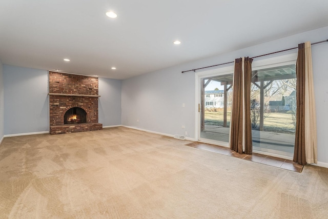 unfurnished living room with recessed lighting, baseboards, a fireplace, and carpet flooring