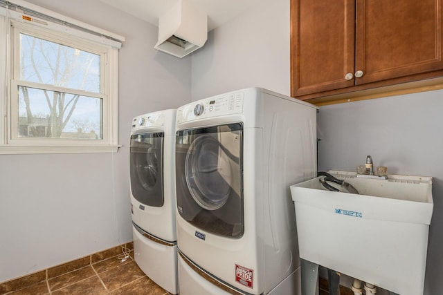 laundry area with washer and dryer, cabinet space, baseboards, and a sink