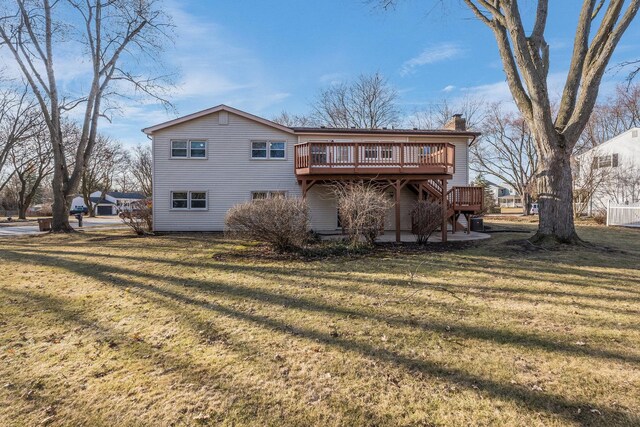 rear view of house with a deck, a lawn, and a chimney