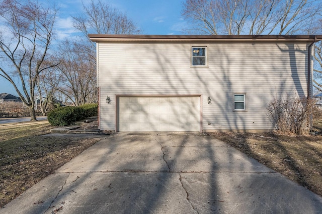 view of side of home featuring driveway and a garage