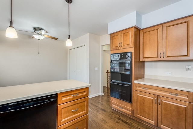 kitchen featuring dark wood finished floors, brown cabinets, black appliances, and light countertops