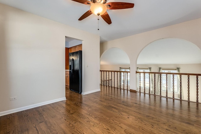 unfurnished room featuring baseboards, wood finished floors, and a ceiling fan