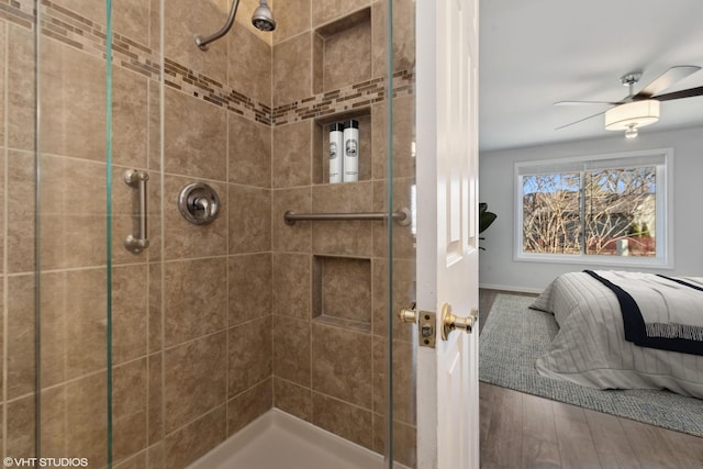 bathroom featuring wood-type flooring, a shower with door, and ceiling fan