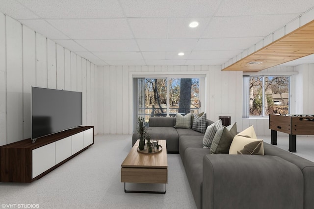 living room featuring carpet flooring and a paneled ceiling