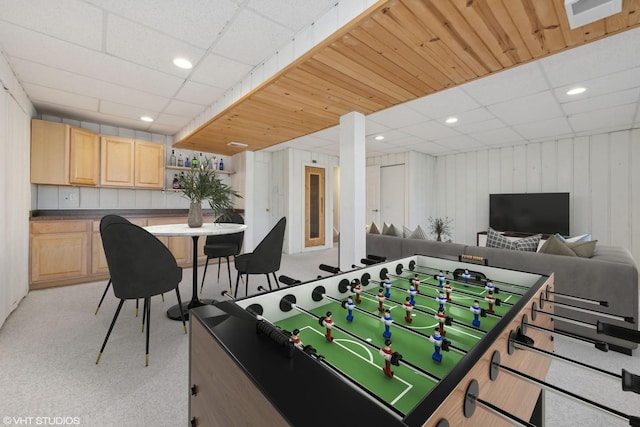 recreation room featuring light carpet and a paneled ceiling