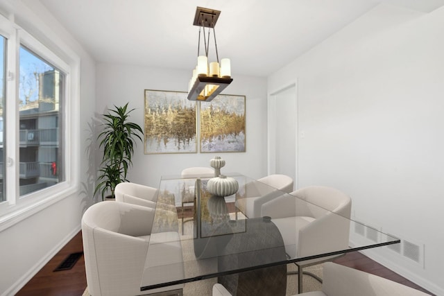 dining area with hardwood / wood-style flooring and a chandelier