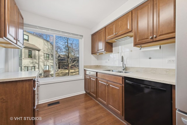 kitchen with dark hardwood / wood-style flooring, sink, decorative backsplash, and black dishwasher