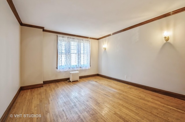 unfurnished room featuring hardwood / wood-style floors, radiator heating unit, and ornamental molding