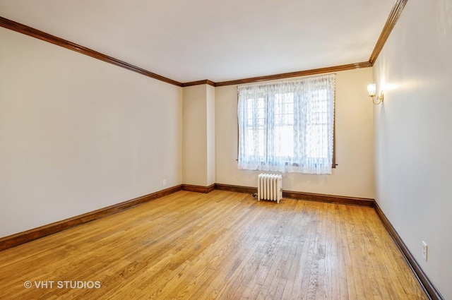 spare room featuring radiator heating unit, ornamental molding, and light hardwood / wood-style floors