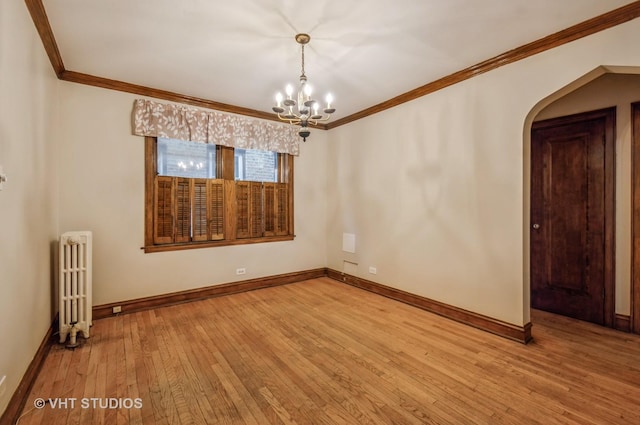 spare room with ornamental molding, radiator heating unit, light hardwood / wood-style flooring, and a notable chandelier