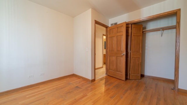 unfurnished bedroom with hardwood / wood-style floors and a closet