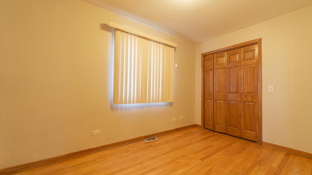 unfurnished bedroom with a closet and light wood-type flooring