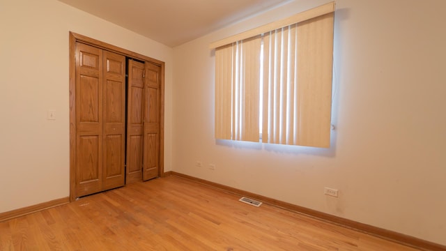 unfurnished bedroom featuring light hardwood / wood-style floors and a closet