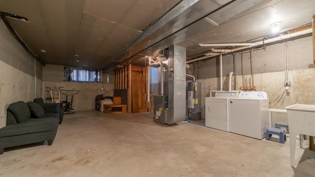 basement featuring washing machine and clothes dryer, heating unit, and gas water heater