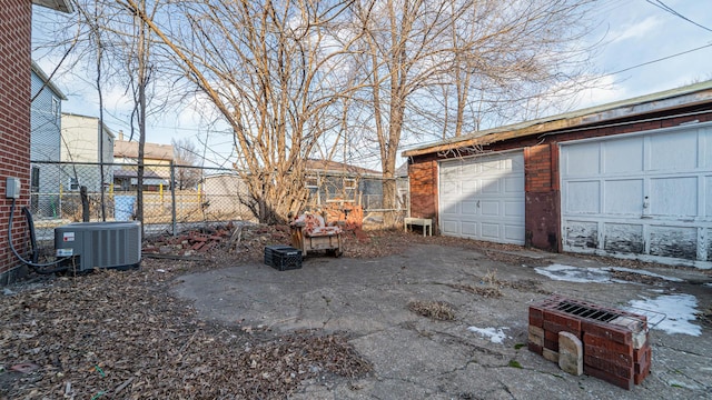 view of yard featuring an outbuilding, a garage, and central air condition unit