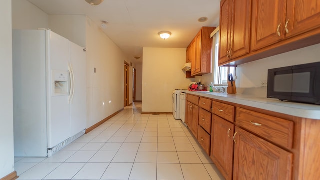 kitchen featuring light tile patterned flooring, range, white refrigerator with ice dispenser, and sink