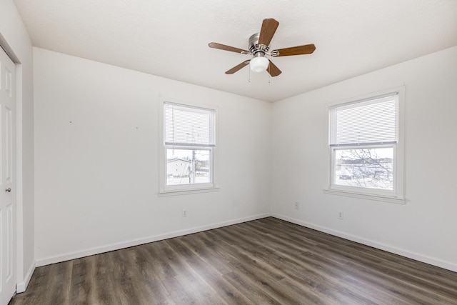 unfurnished room featuring plenty of natural light, wood finished floors, a ceiling fan, and baseboards