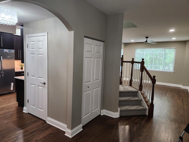 stairs with wood-type flooring and ceiling fan