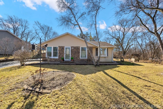 ranch-style home with a front yard and brick siding