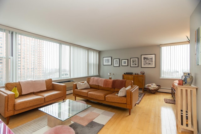 living room with a baseboard heating unit and light hardwood / wood-style flooring