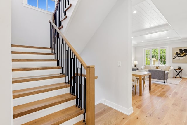 staircase with beamed ceiling and hardwood / wood-style floors