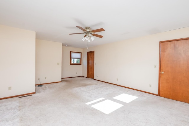 spare room featuring light carpet and ceiling fan