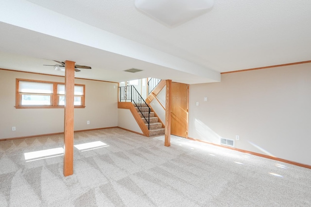 basement with ceiling fan, ornamental molding, and light carpet