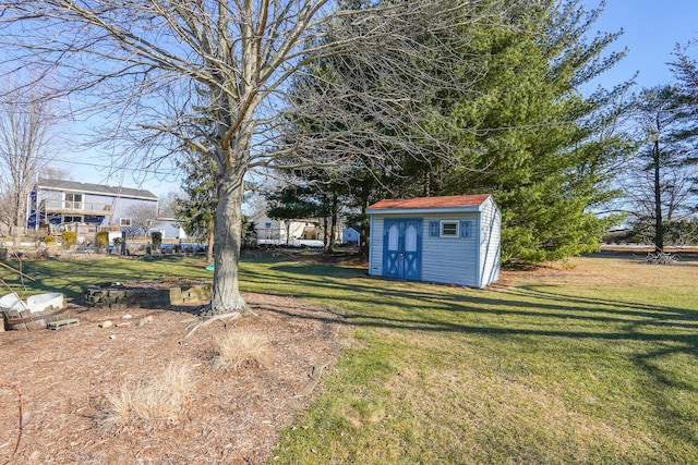 view of yard with a storage shed and an outdoor fire pit