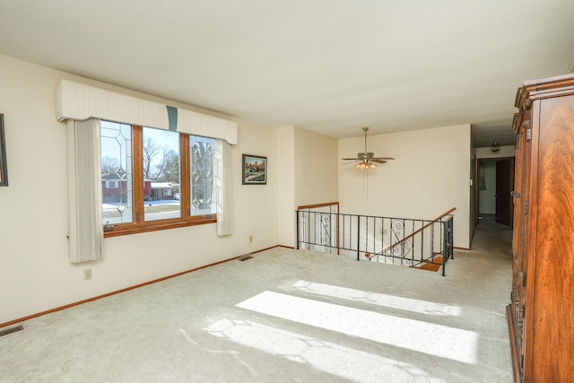 carpeted empty room featuring ceiling fan