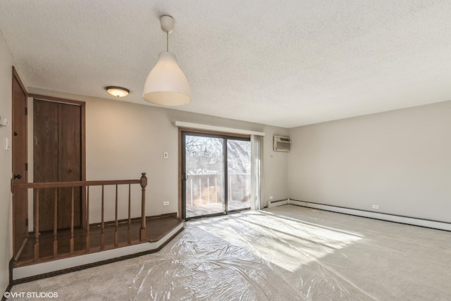 unfurnished room with a baseboard radiator, a wall mounted AC, and a textured ceiling